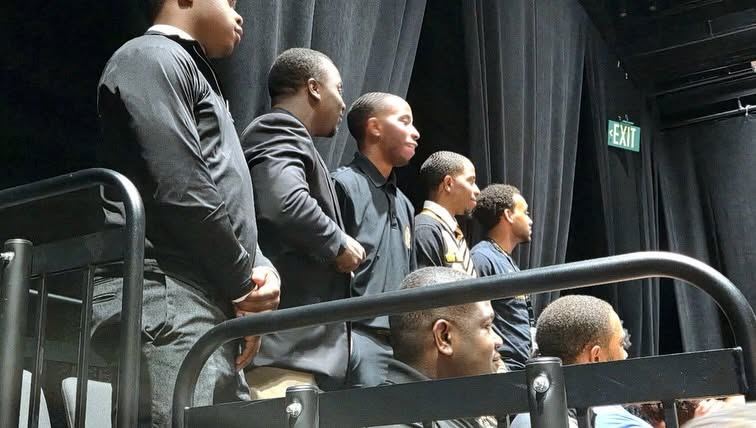 Brothers standing on stage during the opening program